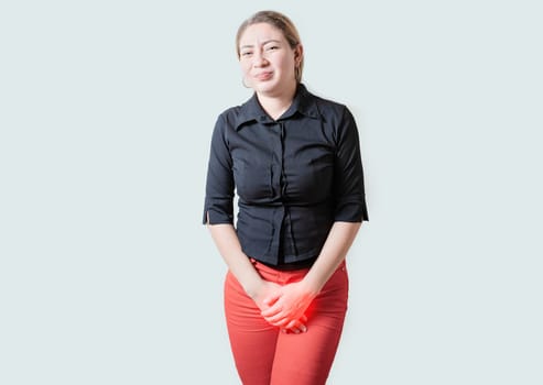 Young woman suffering with urinary problems isolated. Girl with hands on crotch with urinary problems