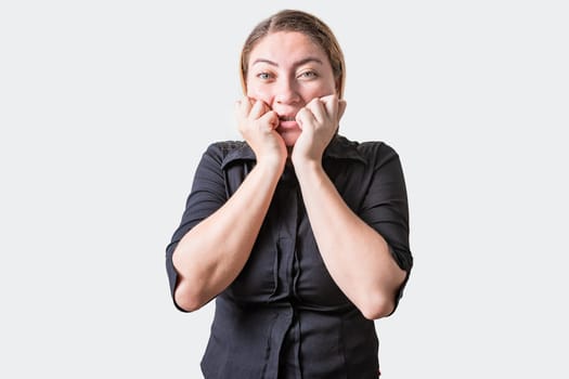 Worried girl biting her nails isolated. Anxious person biting her nails, looking at camera