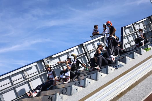 Young ski jumpers on the inrun tower are waiting for their appearance at the FIS Cup Summer Ski Jumping Hinterzarten 2024