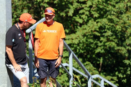 Expert discussion at the ski jump table: v.li. Werner Schuster (Junior Coordinator Ski Jumping German Ski Association) and men's national coach Stefan Horngacher at the COC Cup Summer Ski Jumping Hinterzarten 2024