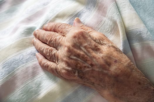 Winkled hand of an 100 old senior elderly women resting peacefully on hospital bedding. Concept of life, aging, health, illness, dignity, compassion, dying ...