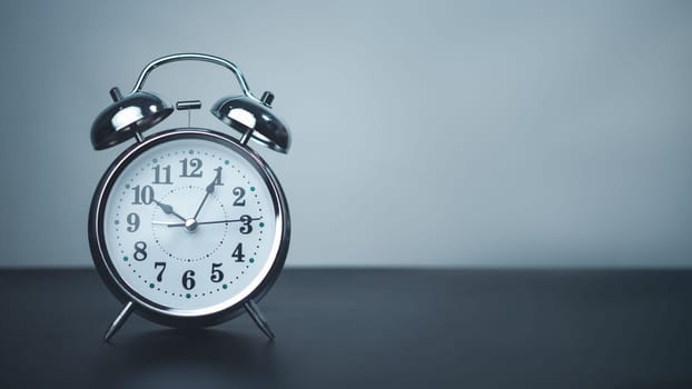 White alarm clock on black table with copy space for preparation of Merry Christmas and Happy new year concept, Start new business, Start up, New trend to next year concept.
