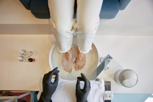 Ceramic bath bowl for legs before pedicure procedure at spa beauty salon. Visiting professional podiatrist office