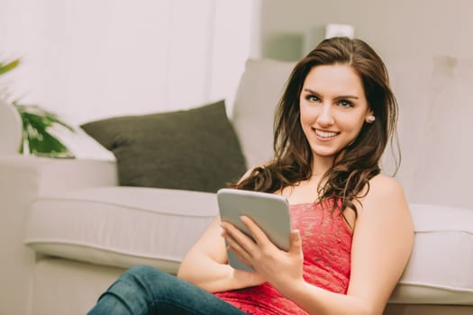 skilled social media manager sits relaxed, holding a tablet. Her bright smile and assured demeanor reflect her readiness to draw attention to your value chain's unique strengths