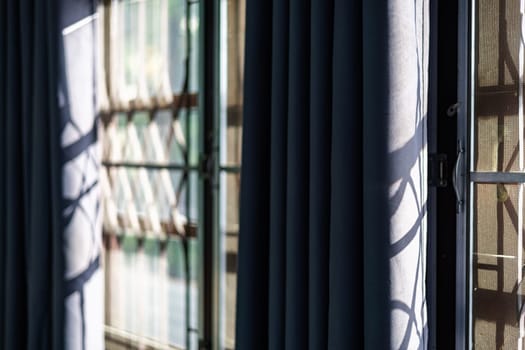 Shadow of the sun rays falling on the wall through the louvers during day.