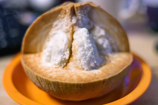 Half Santol on wooden background. Santol has sour taste and the middle of santol is sweeter.