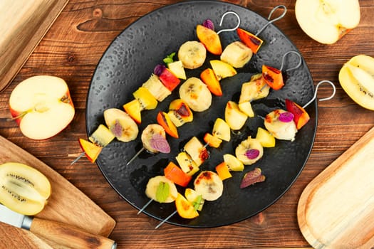 Delicious and homemade skewers with many exotic fruits. Copy space.