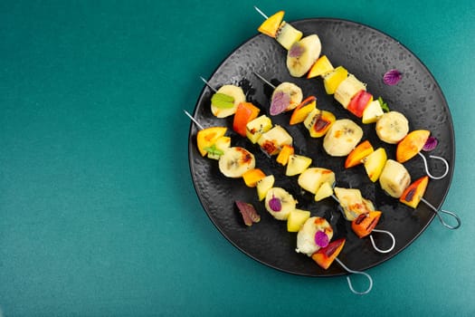 Delicious and homemade skewers with many exotic fruits. Copy space.