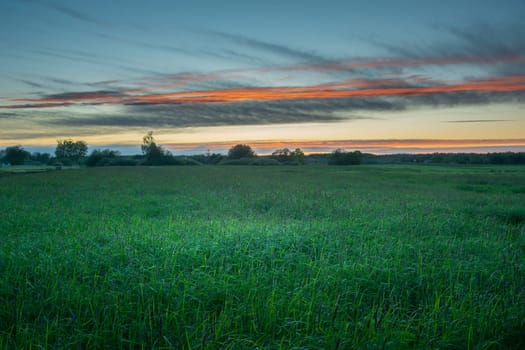 Evening sky over the green meadow, picturesque eastern Poland, summer view