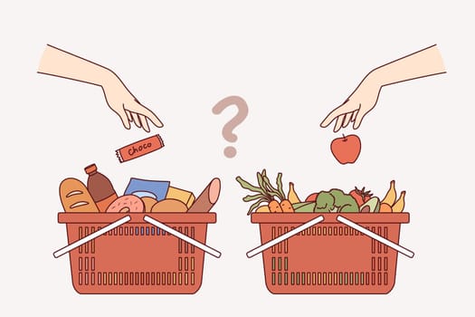 Carts with purchases from grocery supermarket, for concept choosing between healthy eating and junk food. Question is what to buy at grocery store - high-calorie snacks or vegetables and fruits