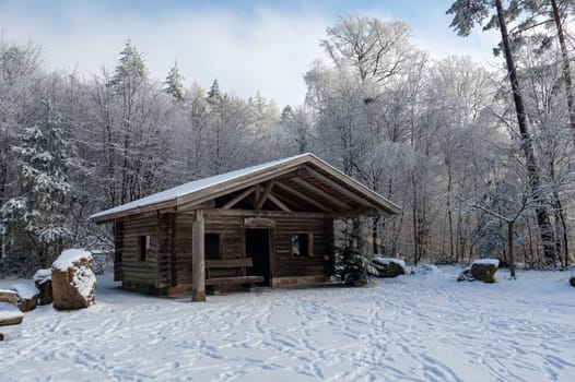 A log cabin in winter with lots of snow and trees