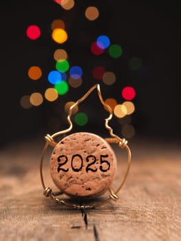 Cork of champagne bottle with inscription Happy New Year 2025, New Year concept, greetings card, Christmas lights