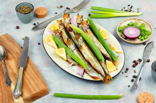 Golden smoke, dried fish. Plate with delicious smoked capelin.
