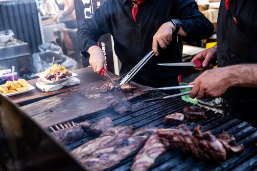 Some excellent pieces of Argentinian beef on a charcoal grill being prepared at open kitchen street food festival in Ljubljana, Slovenia