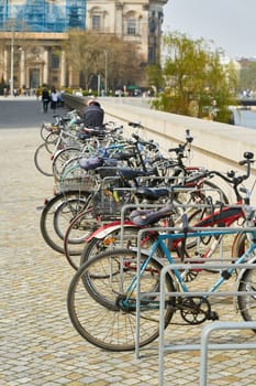 parked bicycles and passers-by on the Humboldt Promenade at the Humboldt Forum on the banks of the Spree in Berlin