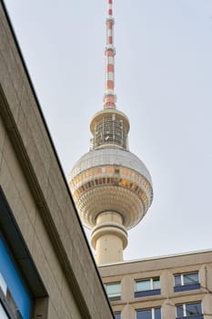 The television tower in Berlin from an unusual perspective hidden behind prefabricated buildings