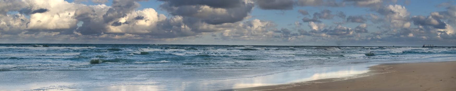 Dramatic ocean waves crash onto the sandy beach under a cloudy sky, showcasing the power and tranquility of nature. Perfect for themes of serenity, nature, and seascape beauty.