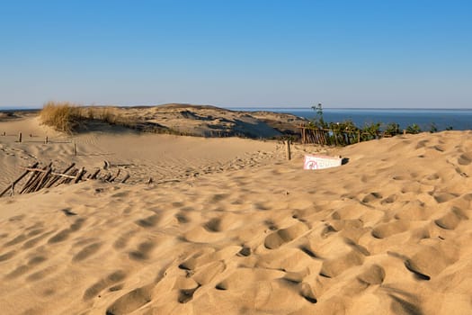 View of nordic dunes, footprints and bushes of Curonian spit, Nida, Klaipeda, Lithuania at sunset on early spring. Signs deep in sands