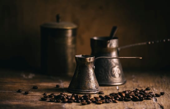 Old coffee pot and coffee bean on rustic wooden table. Vintage oriental coffee on dark background. Still life.