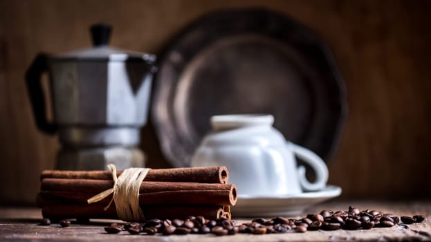 Cup of black coffee, coffee pot and cinnamon flavor on vintage wooden table. Cafe shop retro still life.