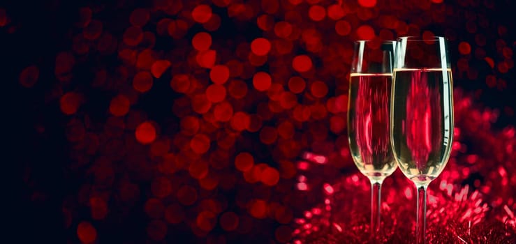 Two champagne glasses on sparkling red bokeh background. Celebration toast flutes. Valentine's day dinner invitation. Christmas and new year holiday party.