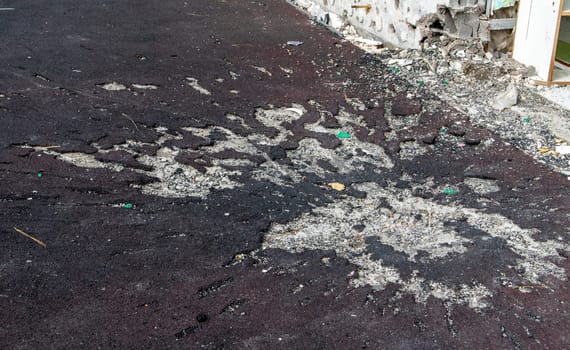 War in Ukraine. Funnel from the explosion in the asphalt. The trace left by the explosion of an artillery shell. Consequences of the rocket attack