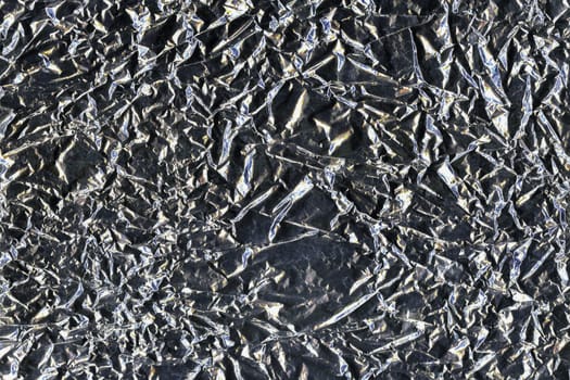 Silver crumpled aluminum foil flat background and texture. Shiny surface