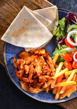 Kebab served with french fries, pitta bread, vegetables and tzatziki