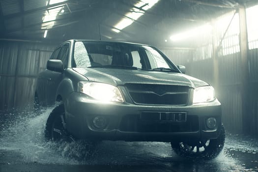 Rugged vehicle driving through flood with headlights illuminating rain