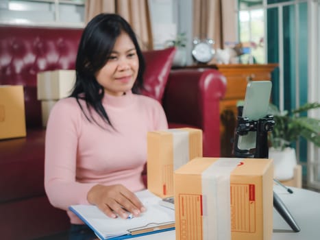 Asian blogger review products and video camera on her phone, sell them online, Business online influencer on social media concept, Ecommerce business live streaming vlog new normal concept.