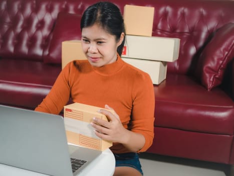 Asia women working business SME online at home her checking order from laptop for customer and online delivery for ready packing, Checking orders from customers with digital laptop, Small business.