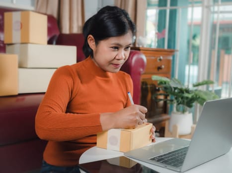 Asian woman receive order on laptop, Startup small business entrepreneur SME, Success young Asian small business owner home office, Online sell marketing delivery, Ecommerce concept, Online business.