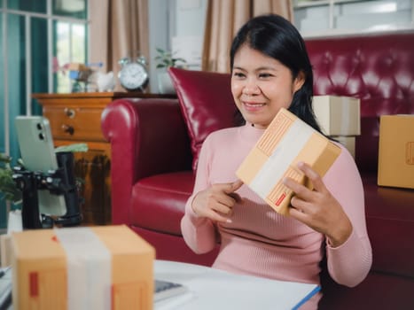 Asian blogger review products and video camera on her phone, sell them online, Business online influencer on social media concept, Ecommerce business live streaming vlog new normal concept.