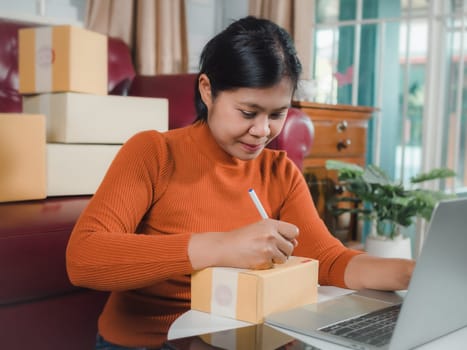 Asian woman receive order on laptop, Startup small business entrepreneur SME, Success young Asian small business owner home office, Online sell marketing delivery, Ecommerce concept, Online business.