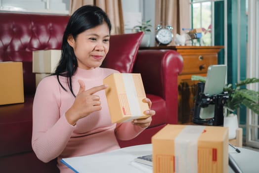 Asian blogger review products and video camera on her phone, sell them online, Business online influencer on social media concept, Ecommerce business live streaming vlog new normal concept.