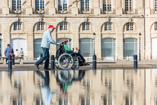 FRANCE, BORDEAUX - SEPTEMBER 20: People visiting a mirror fountain in front of Place de la Bourse in Bordeaux, France on September 20, 2015