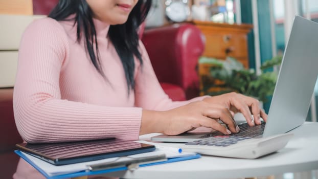 Businesswomen working business SME online at home her checking order from laptop for customer and online delivery for ready packing, Checking orders from customers with digital laptop, Small business.