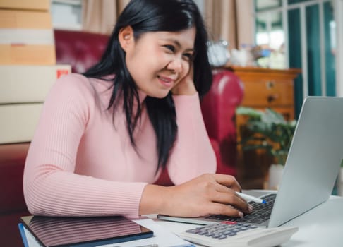 Businesswomen working business SME online at home her checking order from laptop for customer and online delivery for ready packing, Checking orders from customers with digital laptop, Small business.