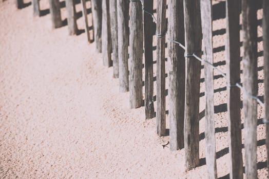 Wooden fence on an Atlantic beach in France, The Gironde Department. Shot with a selective focus