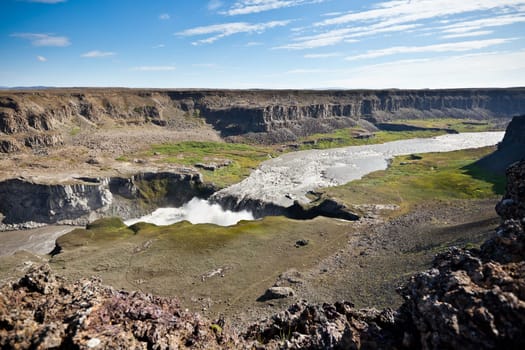 Dettifoss Waterfall in Iceland under a blue summer sky with clouds. Horizontal shot