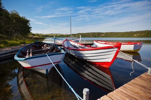Floating Wooden Boats with Paddles and Reflection in a Water