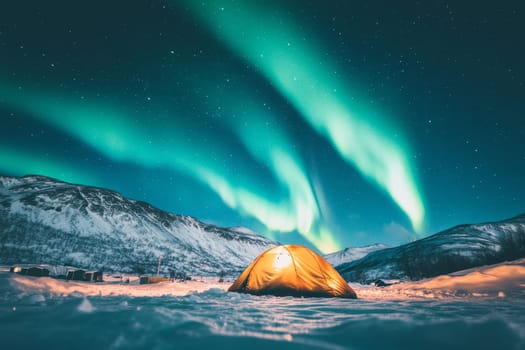 Illuminated tent under spectacular Northern Lights display with snowy mountains in background.