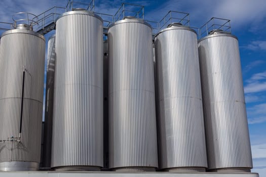 Giant industrial tanks on the bright blue sky background