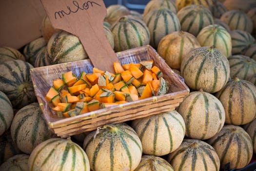 Ripe fresh melons pile in a farmers market. Horizontal shot with a selective focus