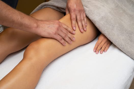 Woman getting legs lymphatic drainage massage in spa salon. Closeup. Body relaxation beauty and body care concept.