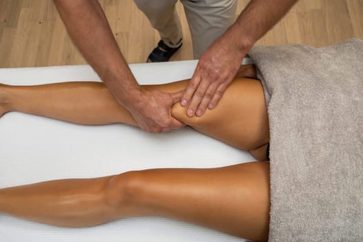 Woman getting legs lymphatic drainage massage in spa salon. Closeup. Body relaxation beauty and body care concept.