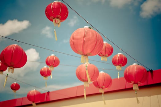Red Chinese Paper Lanterns against a Blue Sky. Horizontal filtered shot