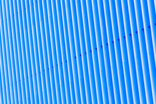 Detail of pattern striped metal facade for blue background