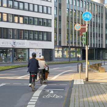 Two cyclists on a street in the city center of Cologne in Germany