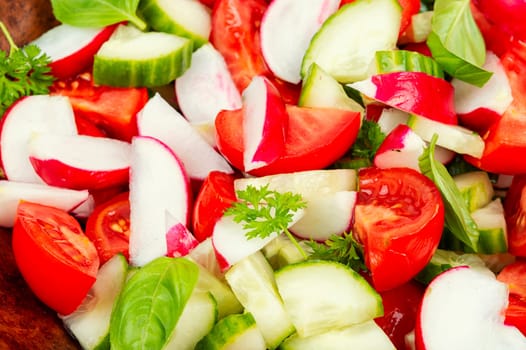 Vegetarian salad of radishes, cucumber and tomatoes. Diet menu.